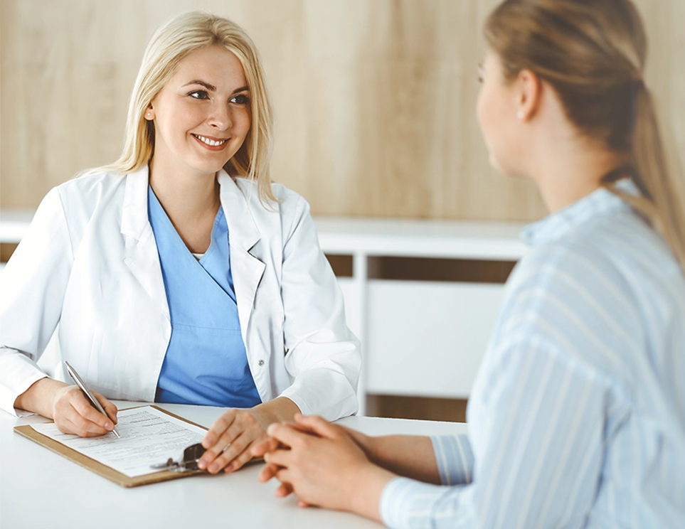 A woman in a white coat talking to a patient