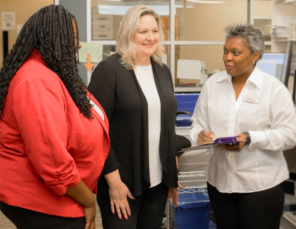 a group of women standing in a pharmacy office