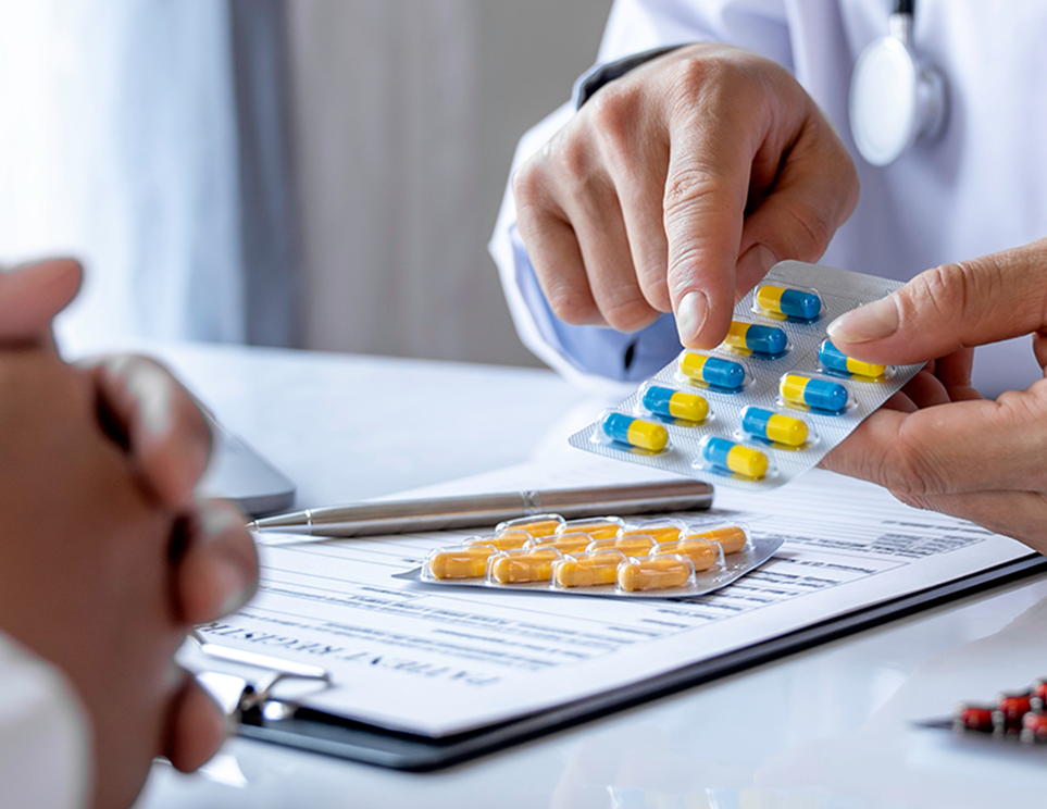 a doctor giving a package of pills to a patient