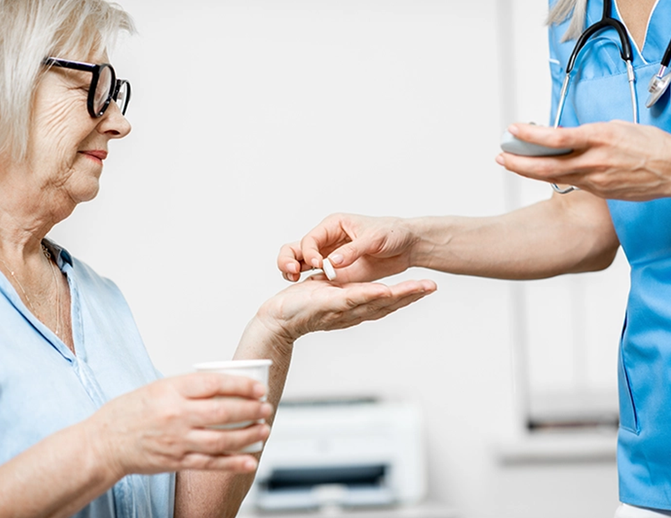 a nurse giving a pill to a woman